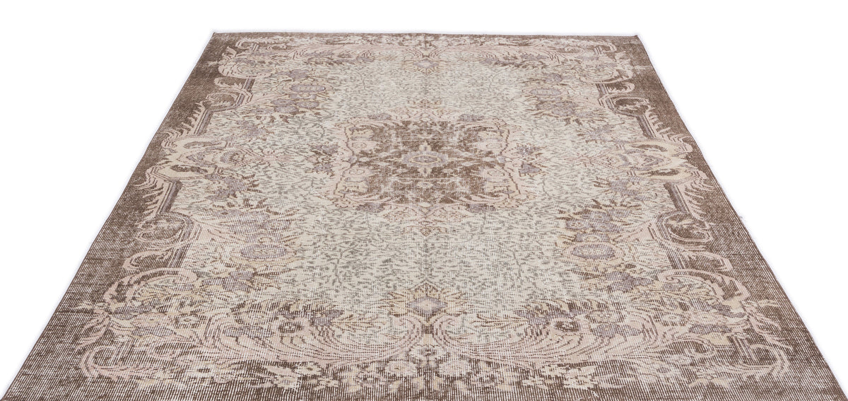 Brown and cream traditional rug with a distressed floral medallion pattern on a white background.