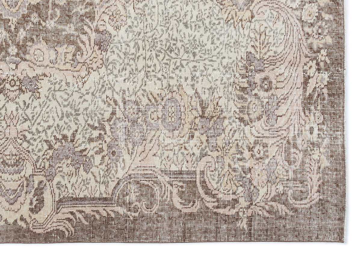 Brown and cream traditional rug with a distressed, faded floral medallion pattern.