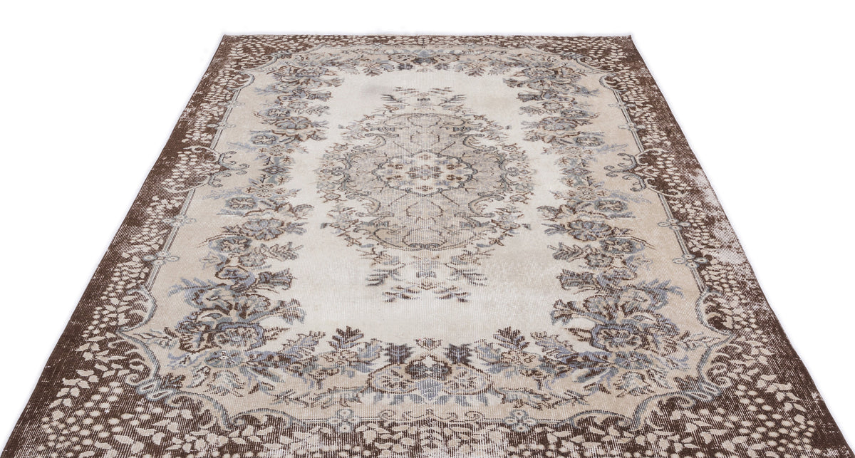 Beige and brown traditional rug with a central floral medallion and ornate border on a white background.