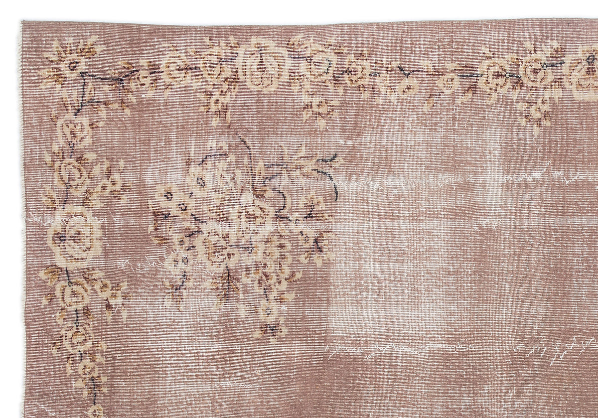 Dusty rose vintage-style rug with a distressed floral border and central bouquet motif on a white background.