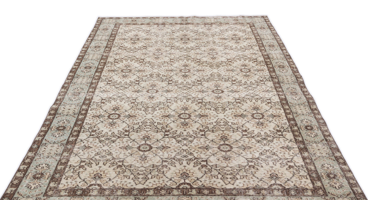 Beige and brown vintage-style rug with a distressed floral medallion pattern and a wide decorative border.