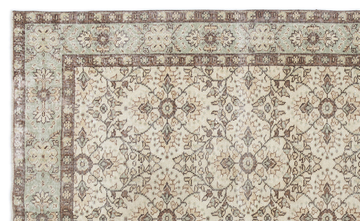 Beige, brown, and sage green traditional rug with a distressed floral medallion pattern and a decorative border.