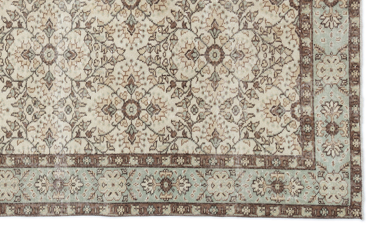 Beige, brown, and sage green traditional rug with a repeating floral medallion pattern and a decorative border.