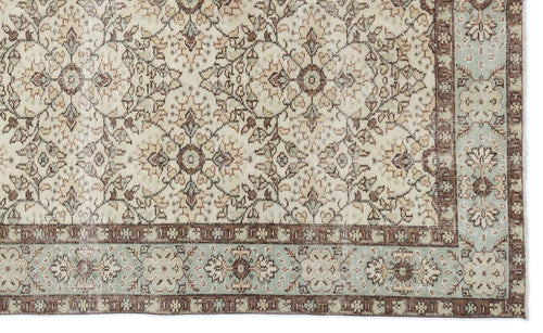Load image 1 in gallery view. Beige, brown, and sage green traditional rug with a repeating floral medallion pattern and a decorative border.