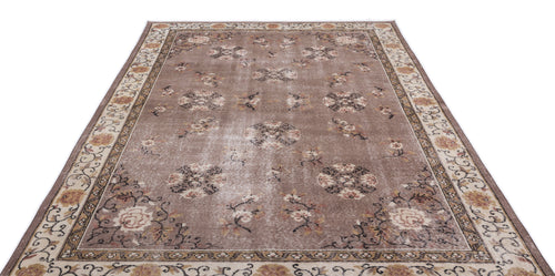 Load image 1 in gallery view. Taupe distressed area rug with a floral medallion pattern and a decorative border on a white background.