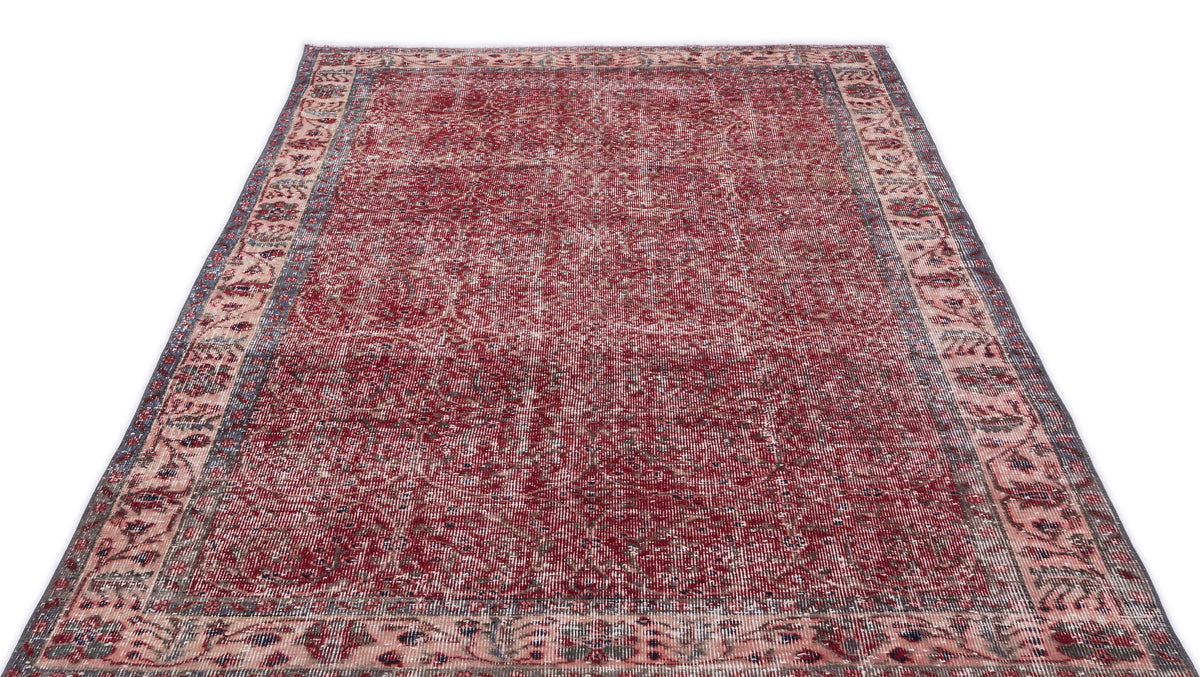 Distressed red and cream traditional rug with an intricate floral medallion pattern and a wide decorative border.