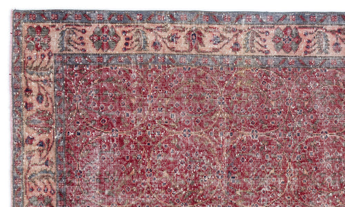Load image 1 in gallery view. Distressed red rug with a faded floral border and a repeating geometric medallion pattern in blue and cream.