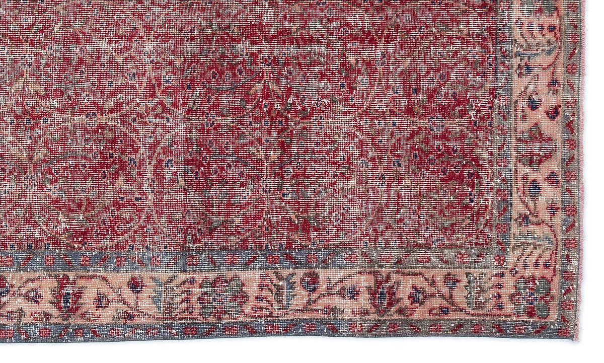 Distressed red and cream traditional rug with a faded floral medallion pattern and a detailed botanical border.