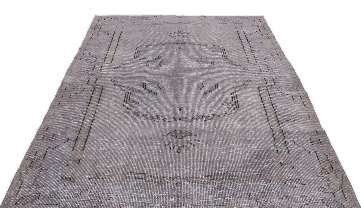 Grey distressed vintage-style rug with a faded central medallion and linear border pattern on a white background.