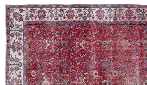 Load image 1 in gallery view. Distressed red rug with a central floral medallion pattern and a cream border featuring intricate botanical motifs.