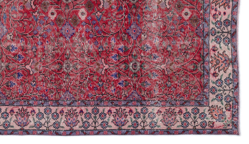 Load image 1 in gallery view. Distressed red traditional rug with a floral medallion pattern and a light pink border featuring blue and purple motifs.