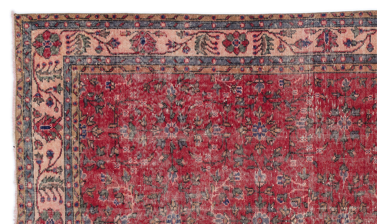 Red traditional rug with a floral field and a multi-layered border in pink, blue, and tan.