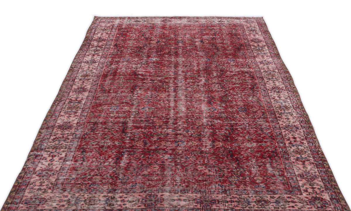 Distressed red and pink vintage-style rug with a traditional ornate border and faded central medallion pattern.
