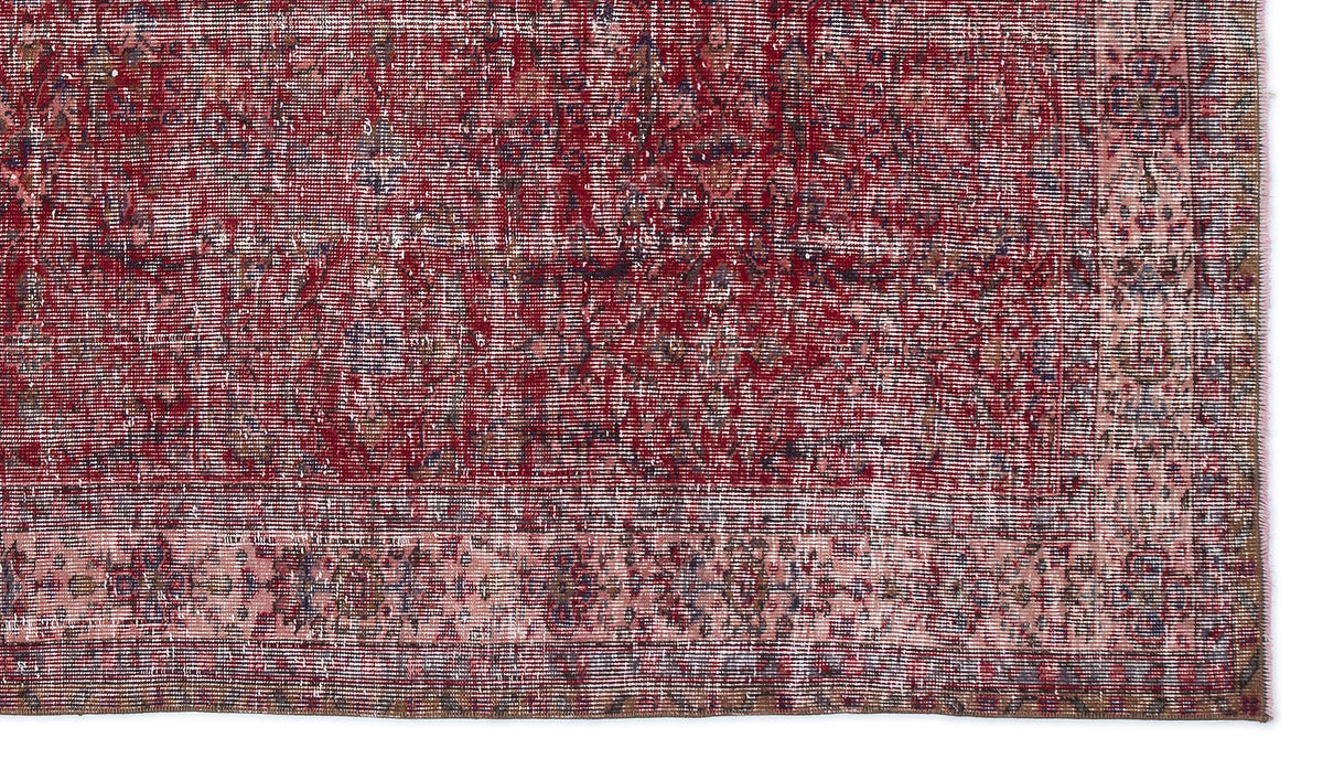 Deep red and faded pink distressed rug with a traditional ornate border and worn, vintage-style texture.