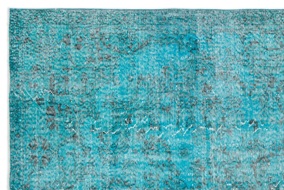 Teal and black distressed vintage-style rug with a faded floral medallion pattern on a white background.