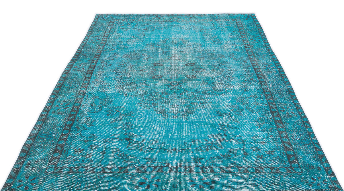 Bright turquoise distressed rug with a dark grey traditional medallion pattern and border on a white background.