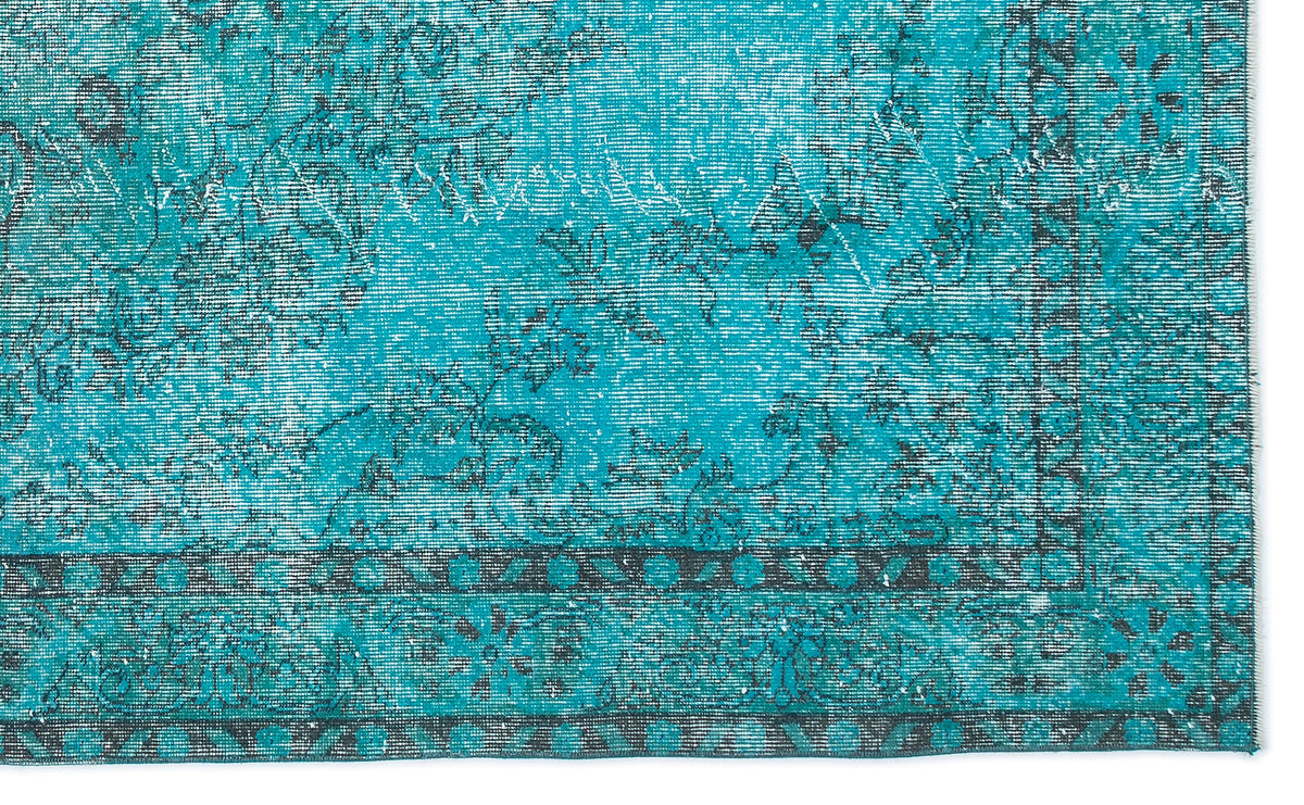 Turquoise and charcoal distressed rug with a traditional floral medallion pattern and a geometric border.