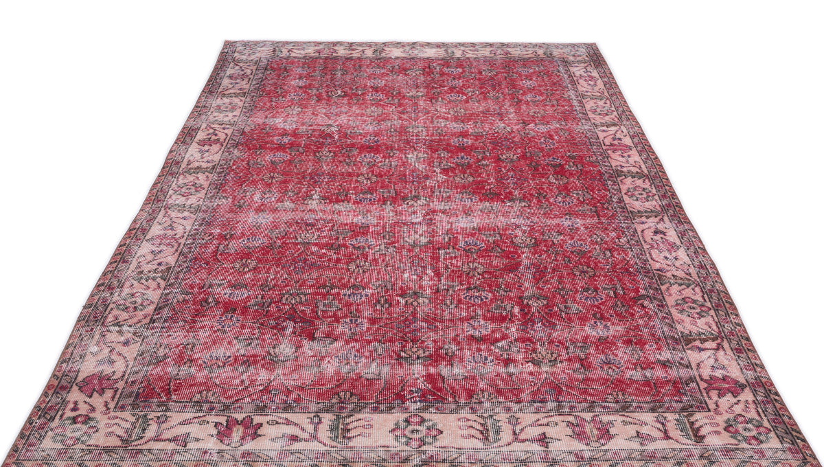 Distressed red and cream vintage-style rug with a traditional floral medallion pattern and a wide decorative border.