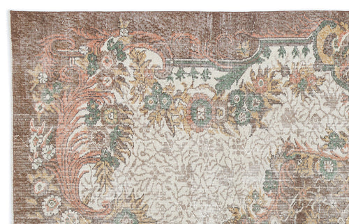 Load image 1 in gallery view. Distressed brown, cream, green, and terracotta rug with a traditional floral medallion pattern.