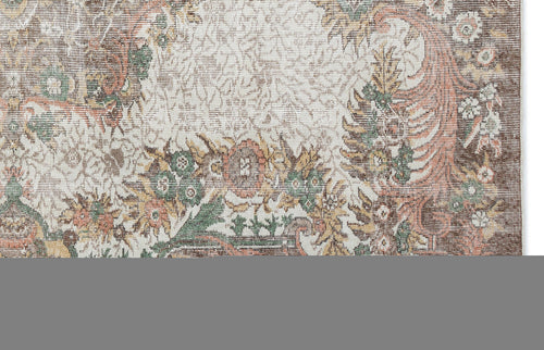 Load image 1 in gallery view. Distressed cream rug with a brown, green, and terracotta floral medallion pattern on a white background.