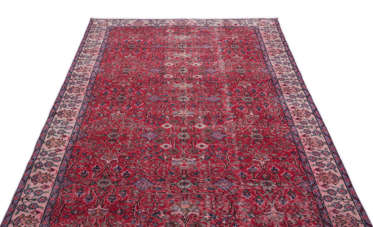 Red vintage-style rug with a distressed floral medallion pattern and a decorative border on a white background.