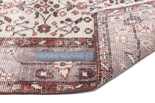Load image 1 in gallery view. Beige and rust floral patterned rug with a folded corner revealing the woven backing and a metal ruler for scale.