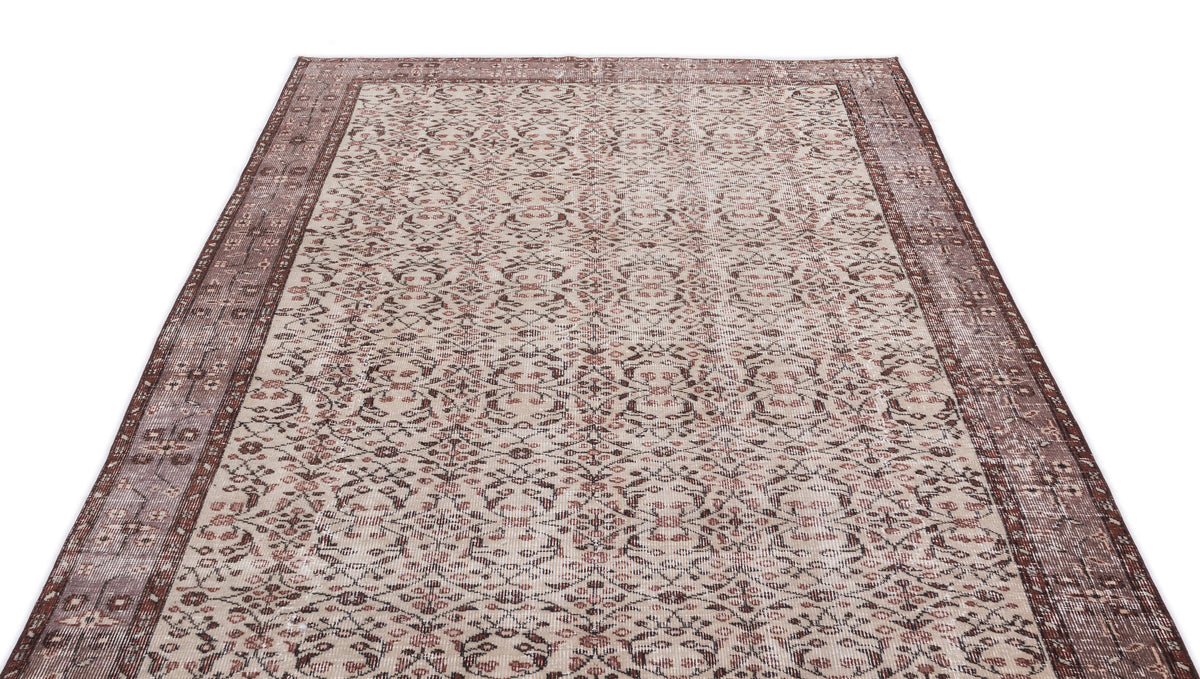 Beige and brown vintage-style rug with a distressed floral medallion pattern and a wide decorative border.