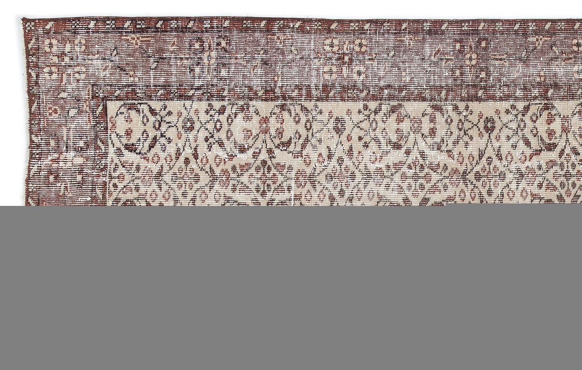 Distressed cream and brown rug with a traditional floral medallion pattern and a wide, ornate border.