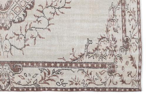 Load image 1 in gallery view. Beige and brown vintage-style rug with a distressed floral medallion pattern and a geometric border.