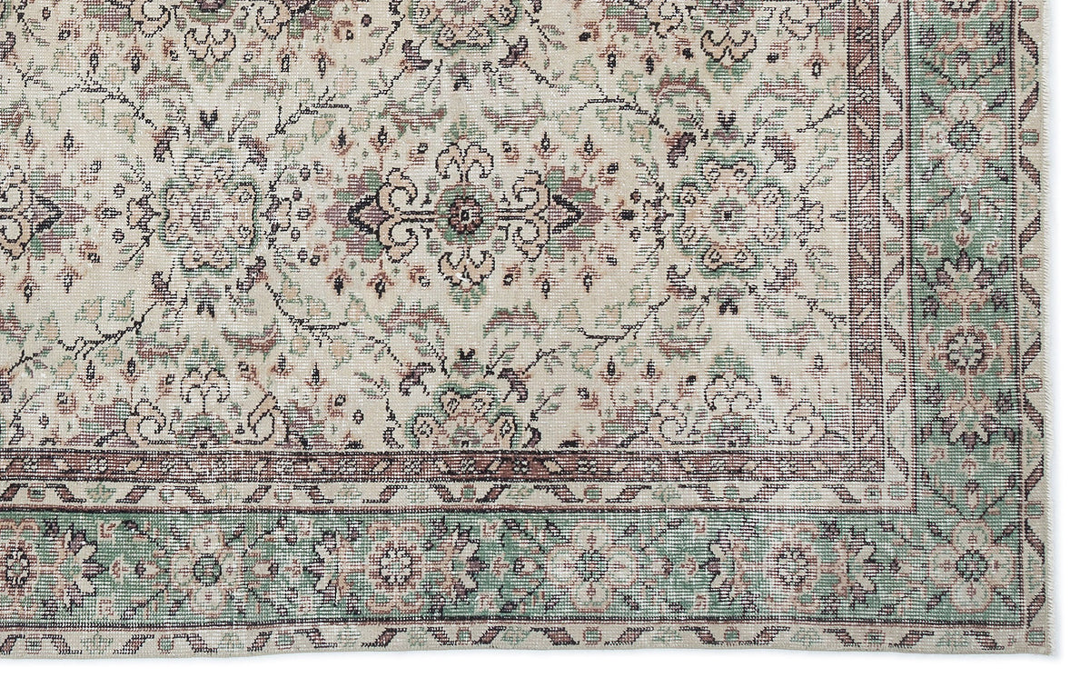 Cream rug with a traditional floral medallion pattern in sage green, dusty rose, and charcoal on a white background.