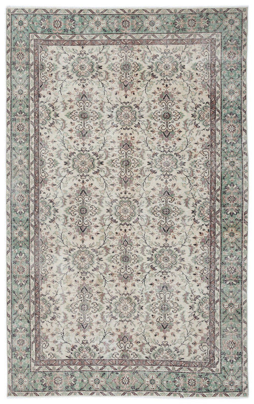 Load image 1 in gallery view. Cream, sage green, and mauve traditional rug with a distressed floral medallion pattern and a decorative border.