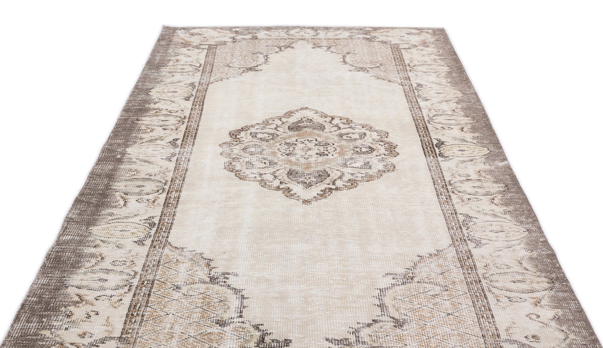 Beige and taupe distressed vintage-style rug with a central medallion and ornate border pattern on a white background.