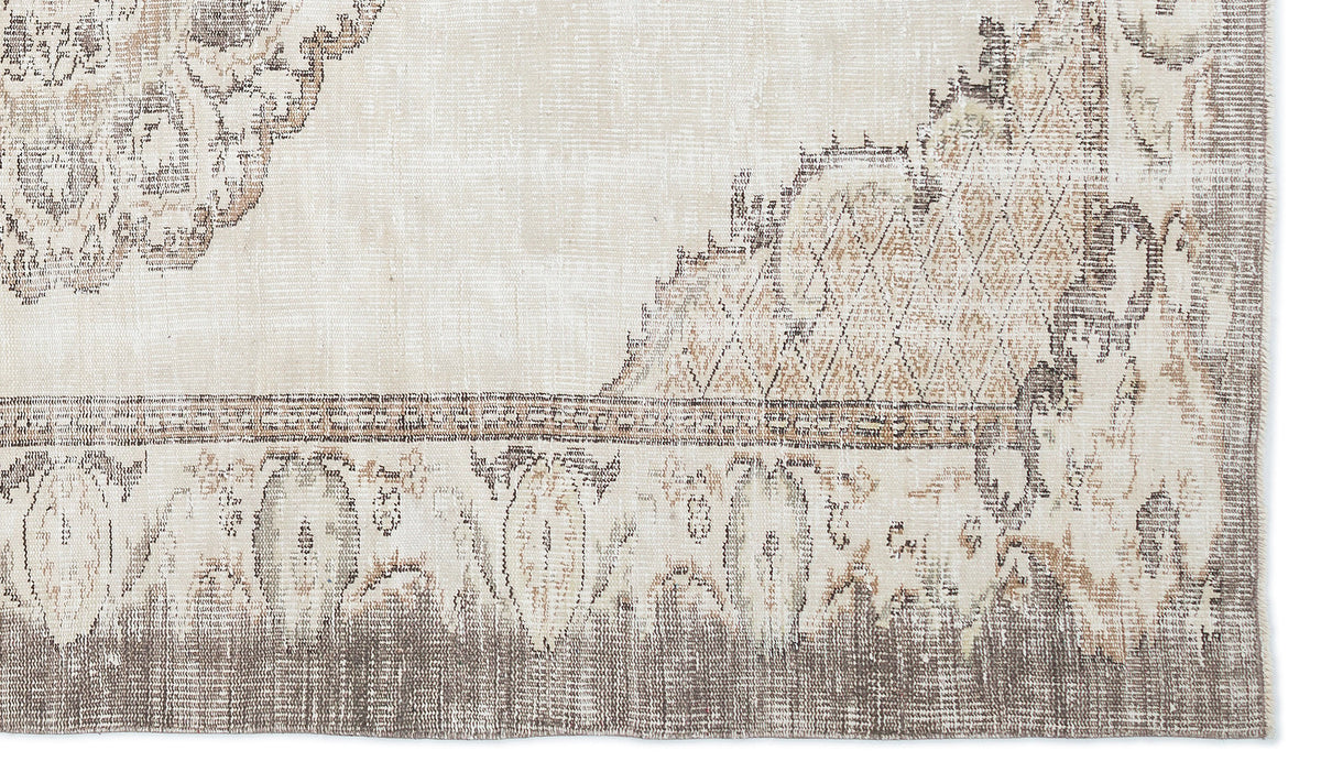 Beige and taupe distressed rug with a faded traditional medallion pattern and geometric border.
