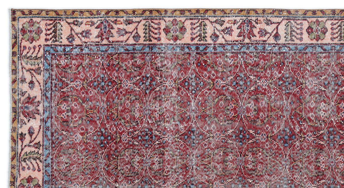 Red and blue traditional rug with a distressed floral medallion pattern and a multi-colored geometric border.