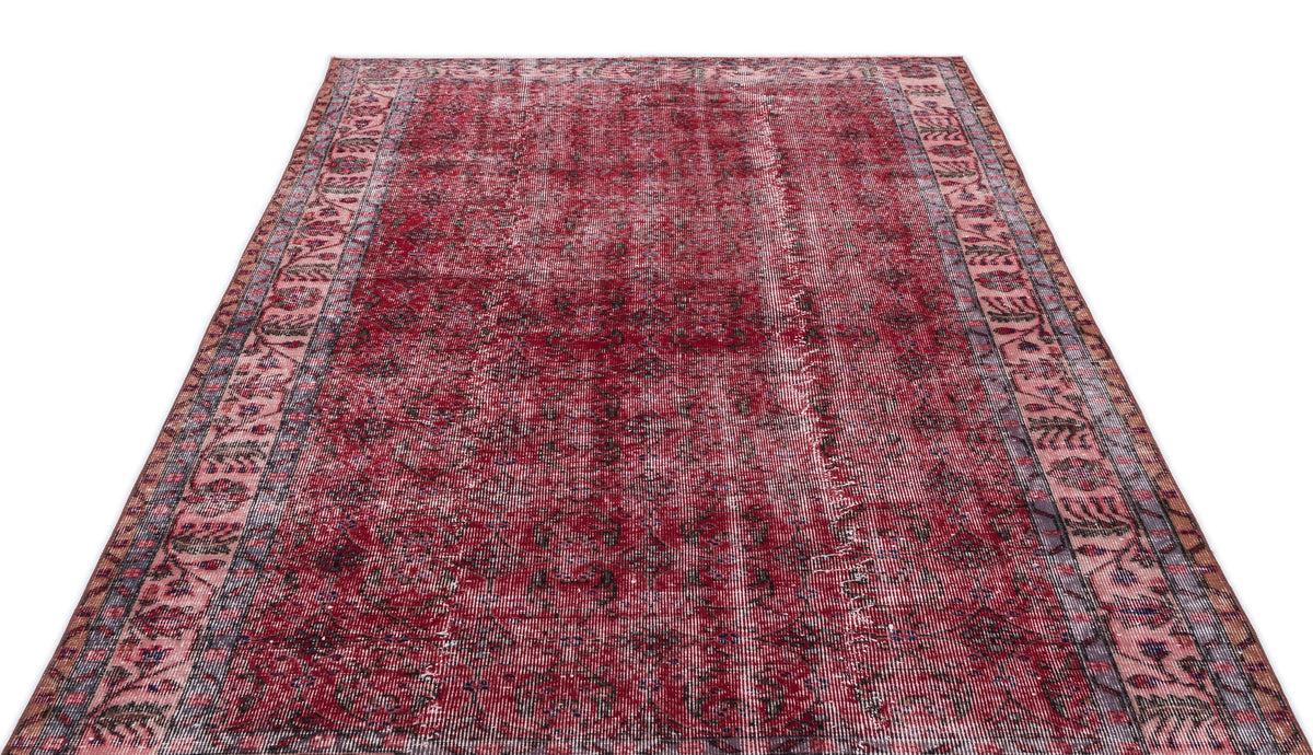 Deep red distressed Persian-style rug with a dark central medallion and intricate floral border on a white background.