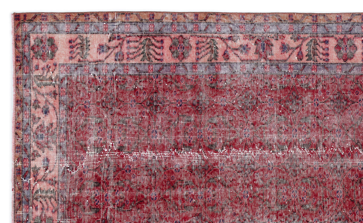 Distressed deep red rug with a faded floral border in pink, blue, and orange on a white background.