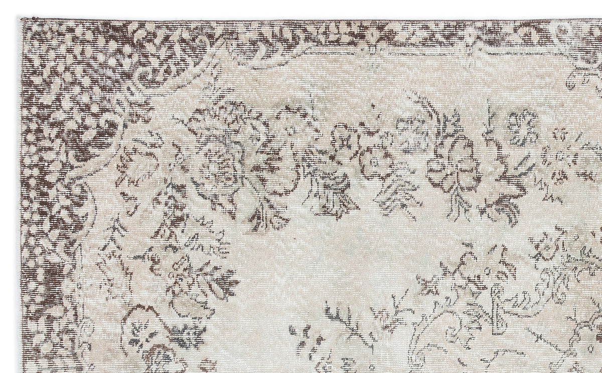 Beige and brown distressed rug with a faded floral medallion pattern on a white background.