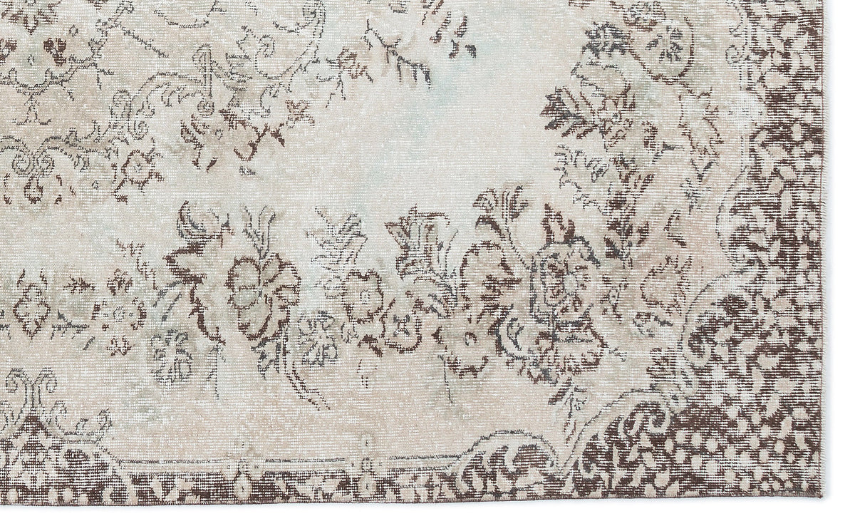 Beige and brown distressed rug with a faded floral medallion pattern.