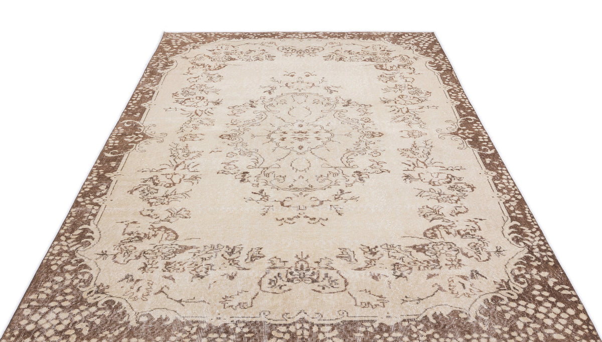 Beige and brown vintage-style rug with a central floral medallion and ornate border pattern on a white background.
