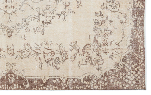 Load image 1 in gallery view. Beige and brown rug with a distressed floral medallion pattern and a wide decorative border.