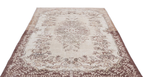 Load image 1 in gallery view. Beige and brown distressed area rug with a central floral medallion and ornate border on a white background.