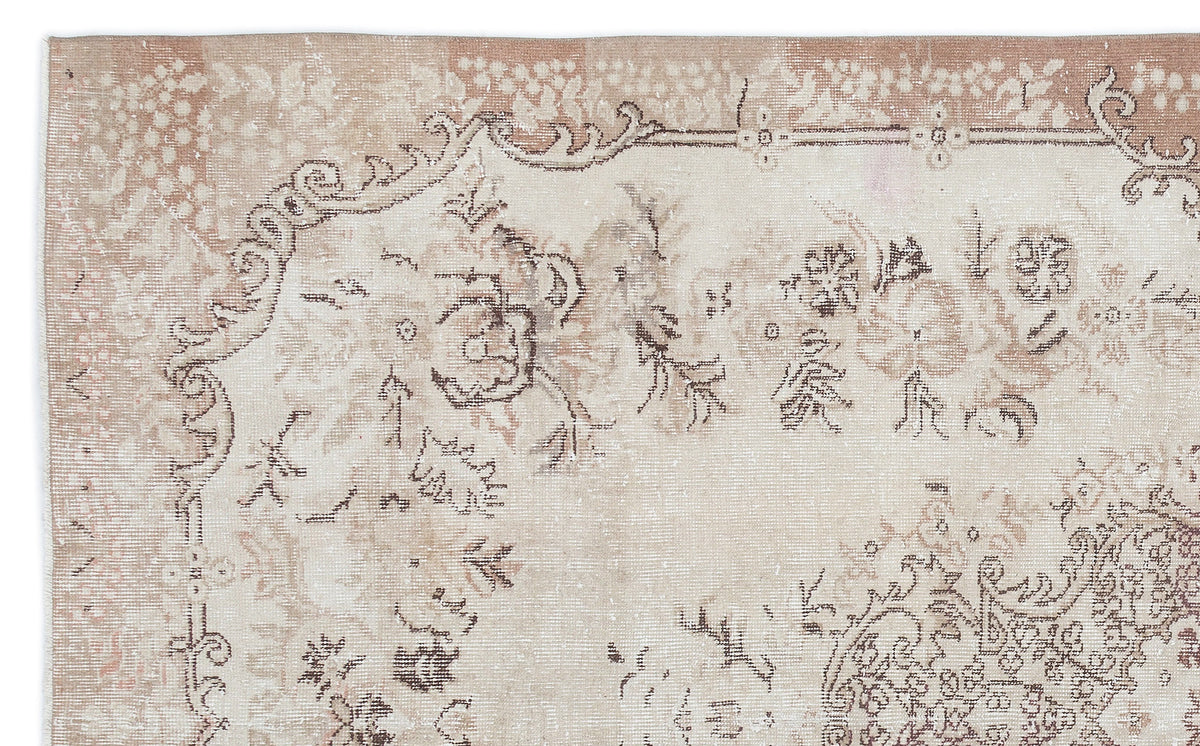 Beige and taupe vintage-style rug with a distressed floral medallion pattern and ornate border.