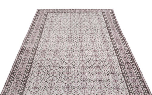 Load image 1 in gallery view. Cream and mauve area rug with a repeating geometric medallion pattern and a wide, detailed border.