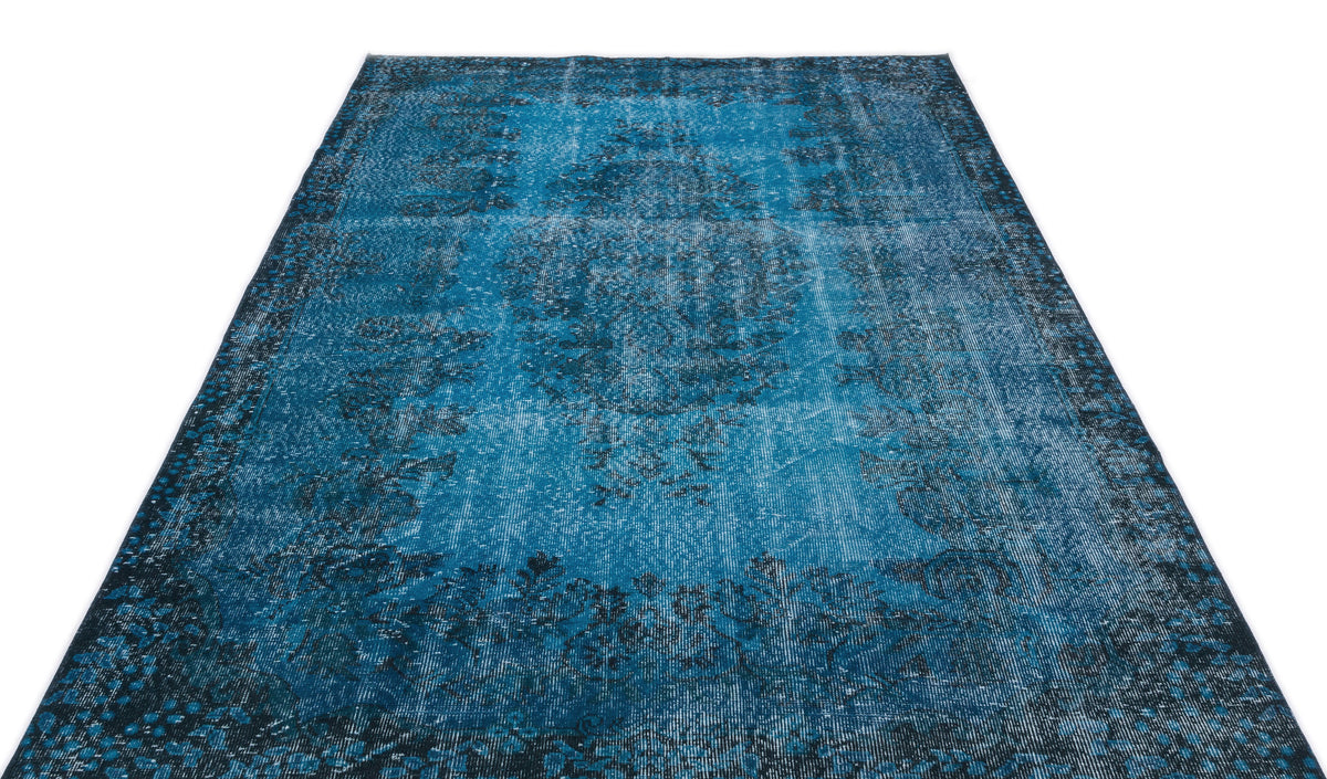 Distressed blue and black vintage-style rug with a central medallion and ornate border on a white background.