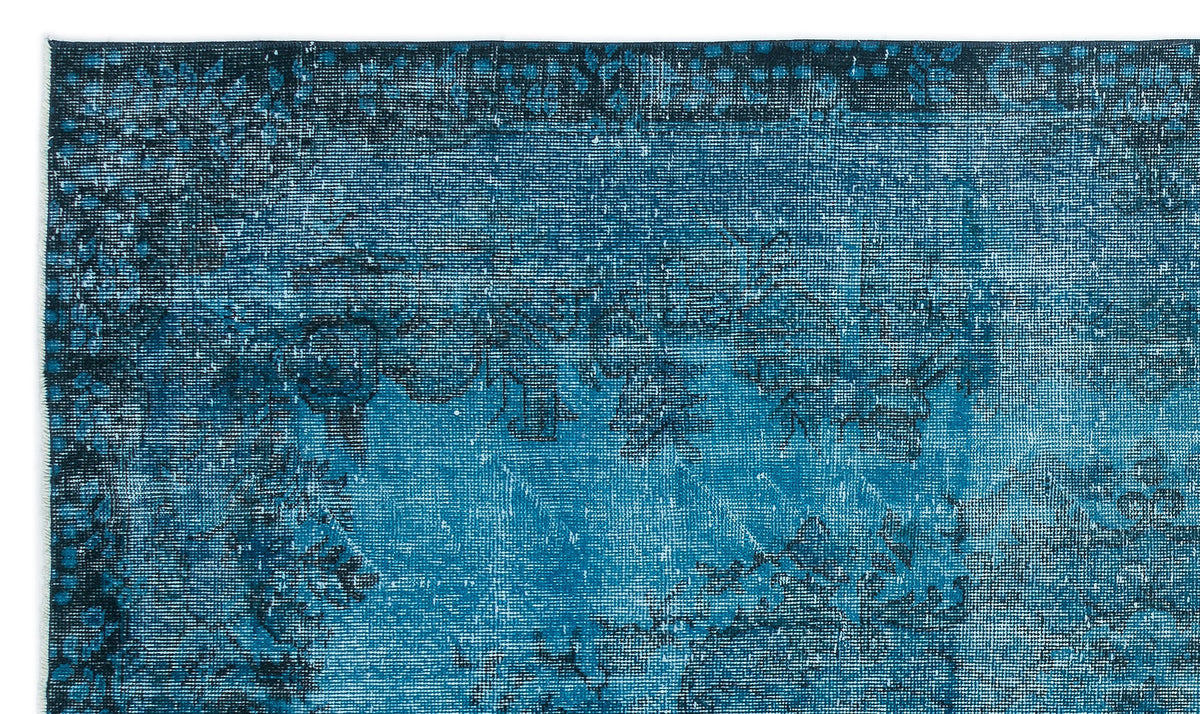 Teal and navy blue distressed rug with a faded traditional floral medallion pattern.