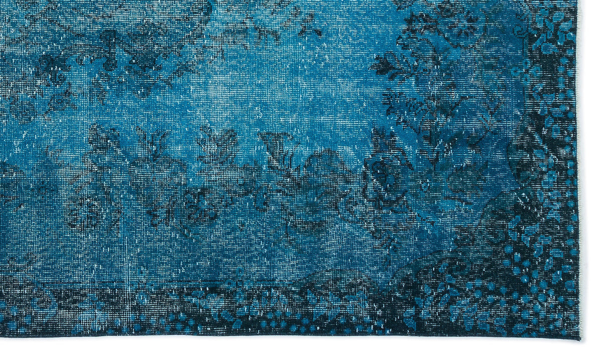Deep blue distressed rug with a faded floral pattern and dark navy border.