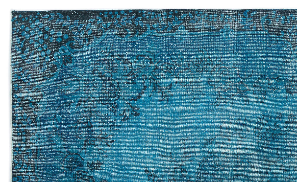 Teal and black distressed rug with a traditional floral medallion pattern and ornate border.