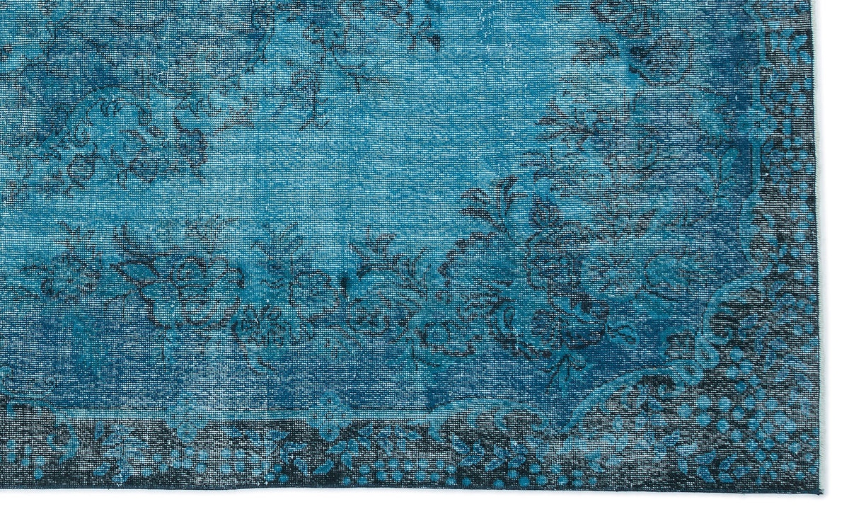 Teal and black distressed rug with a traditional floral medallion pattern and a dark border.