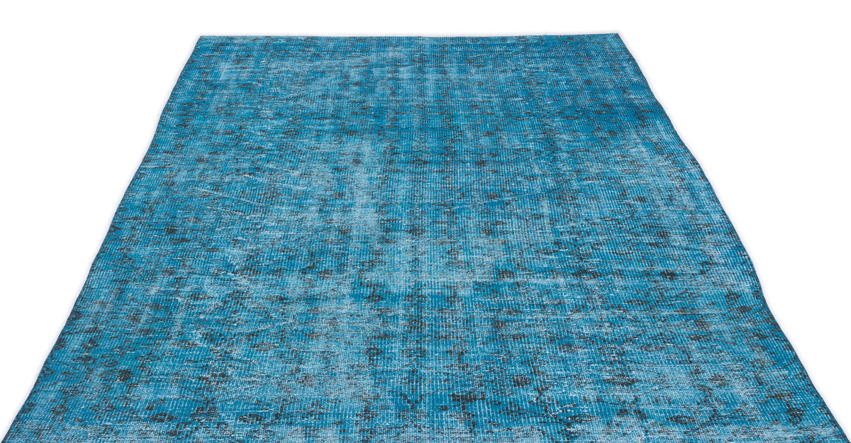 Bright blue distressed rug with a faded, dark grey traditional medallion pattern on a white background.