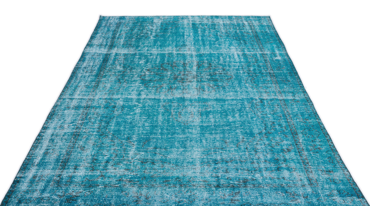 Teal and black distressed area rug with a faded traditional medallion pattern on a white background.